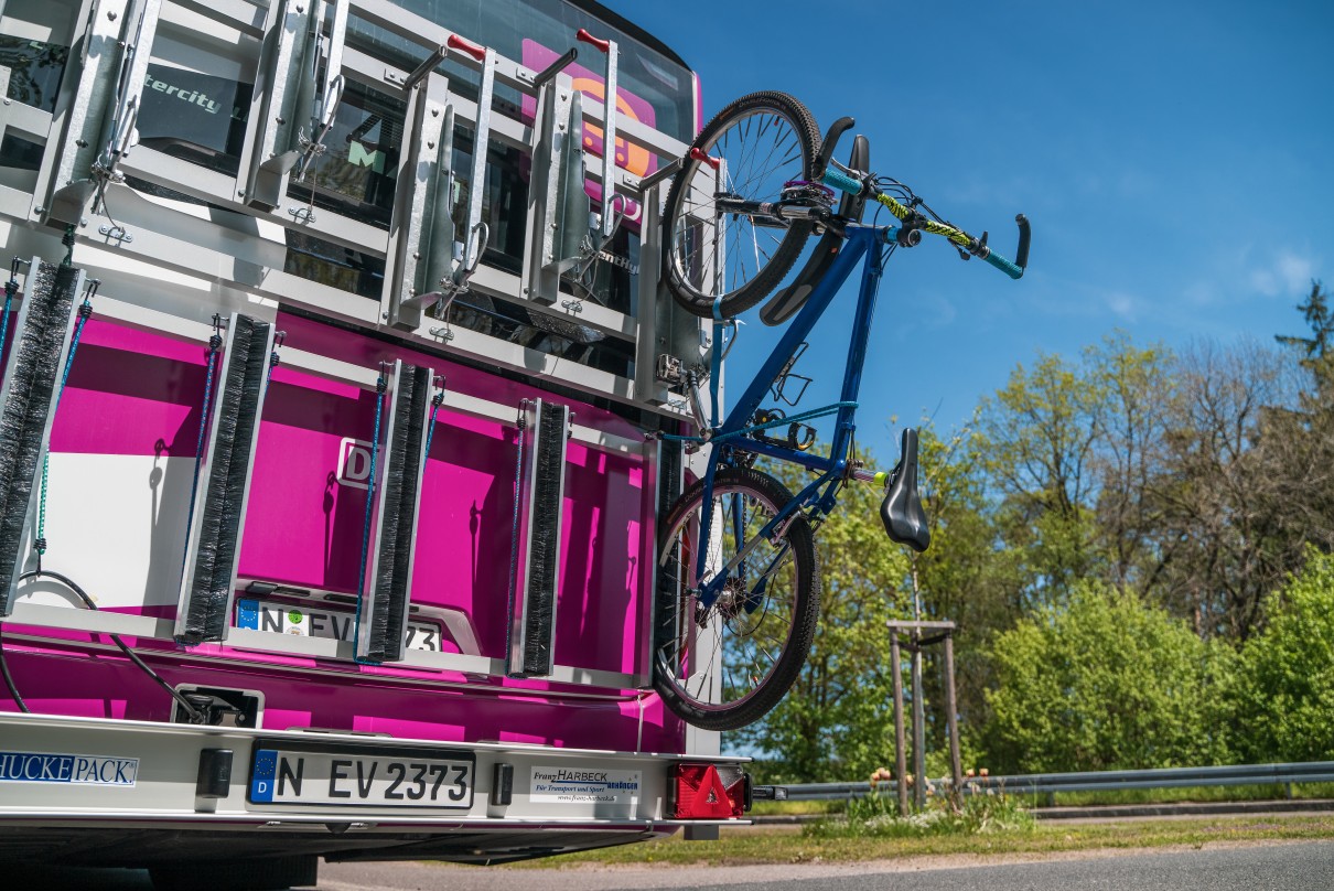 Das Foto zeigt, wie Fahrräder zur Mitnahme an Bussen des Neuen Ersatzverkehrs angebracht werden.