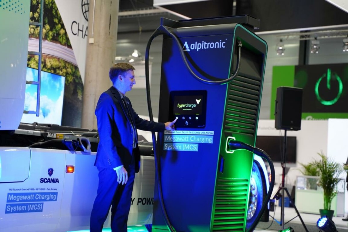 A man operates a megawatt charger which is being exhibited at a trade fair.