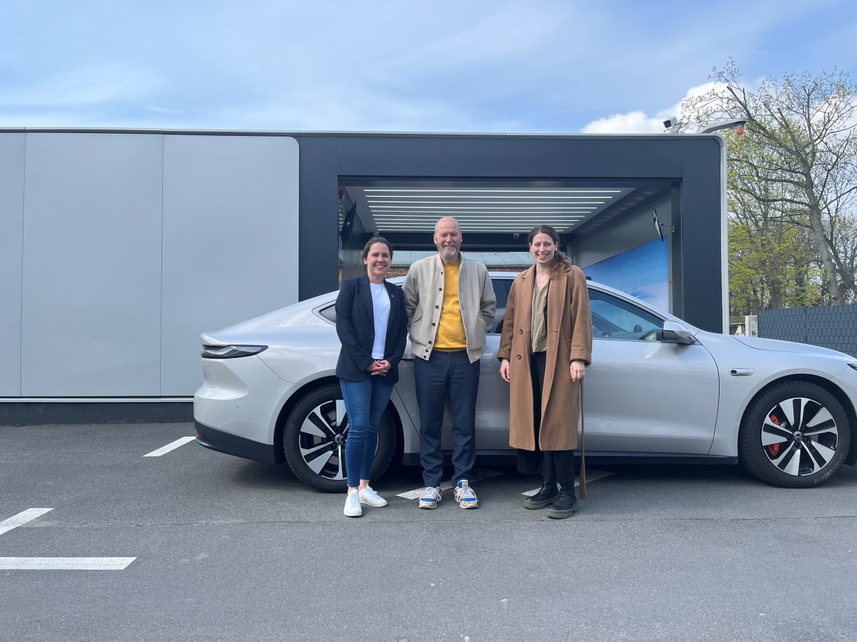 Dr. Stefan Carsten, futurist and curator of the BUS2BUS Future Forum with two NIO employees in front of a NIO Power Swap Station (PSS) in Berlin. 