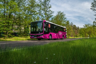 Es wird ein Bus des Neuen Ersatzverkehrs in der Farbe Verkehrspurpur gezeigt.