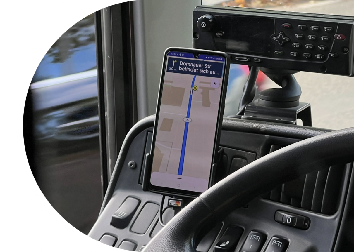 Smartphone mit ioki Route App am Fahrerarbeitsplatz