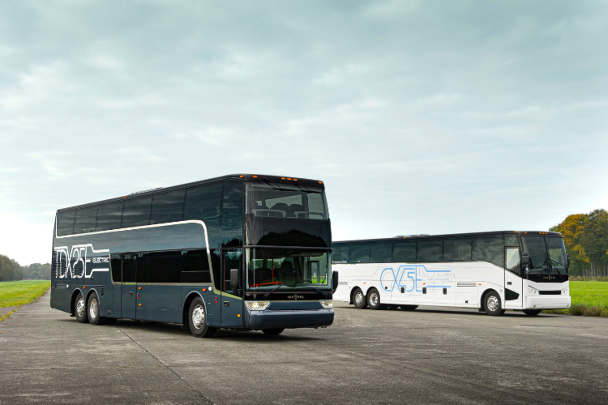 Zwei E-Reisebusse sind auf einer Betonfläche geparkt. Zwei E-Reisebusse sind auf einer Betonfläche geparkt.